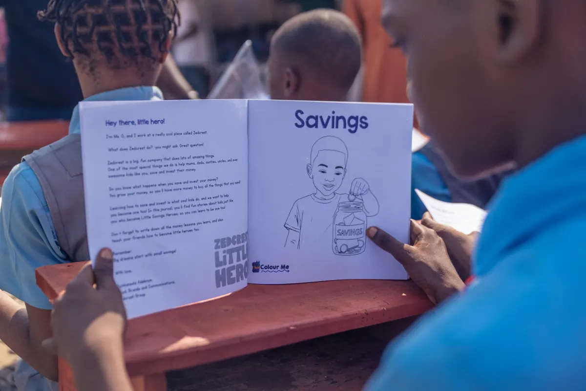 A pupil reading the savings chapter of the Little Heroes book