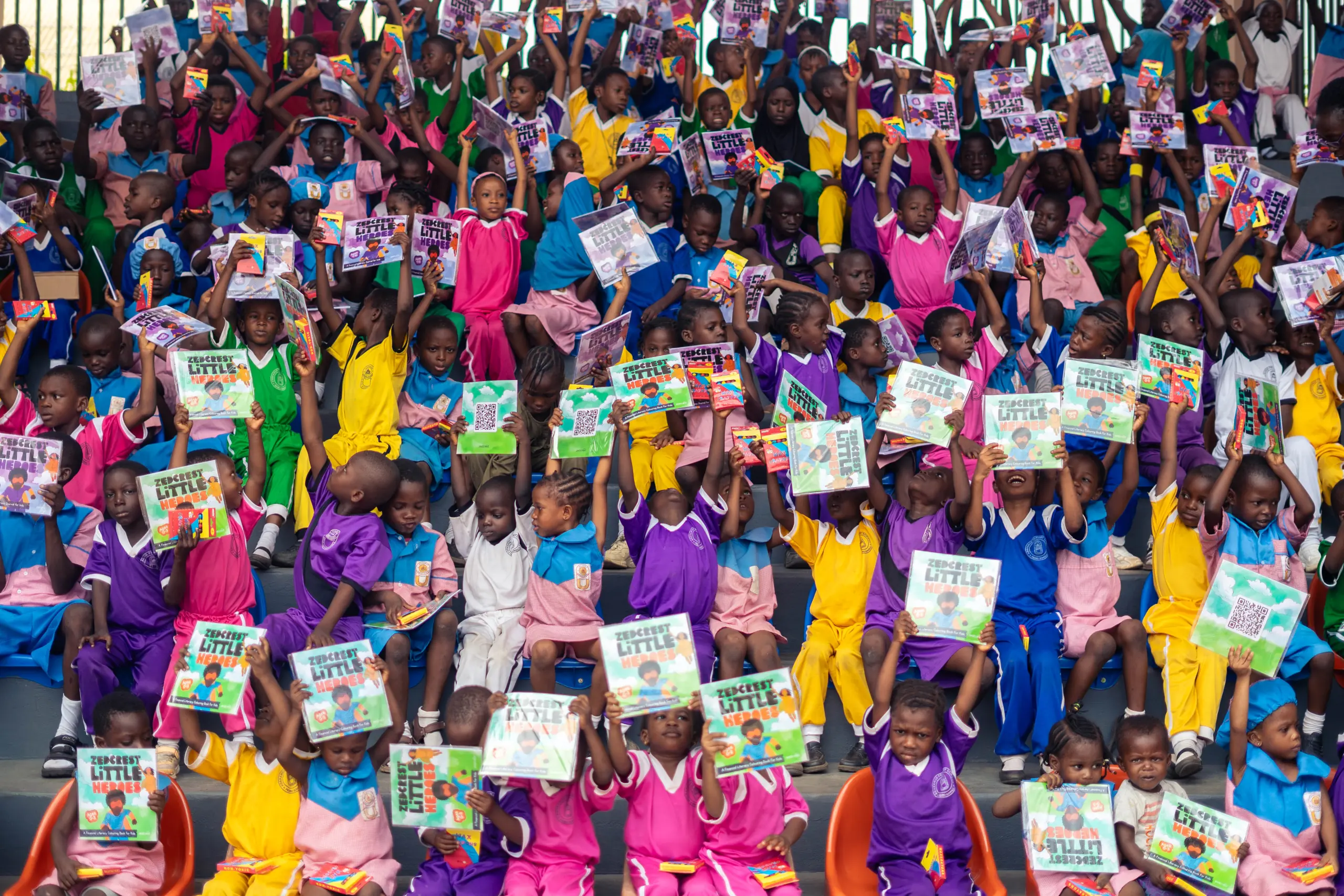 Children holding their Little Heroes financial literacy books